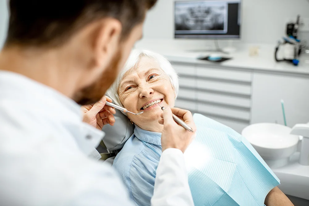 Elderly woman during the medical examination with male dentist in the dental office. Denture care