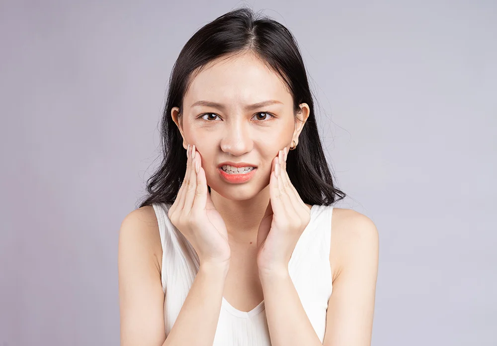Asian woman feels pain teeth grinding bruxism