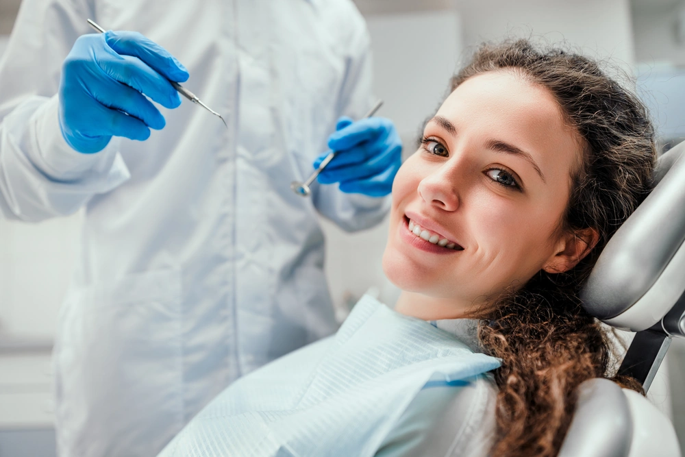 Smiling young woman receiving dental checkup. close up view. Healthcare and medicine concept.