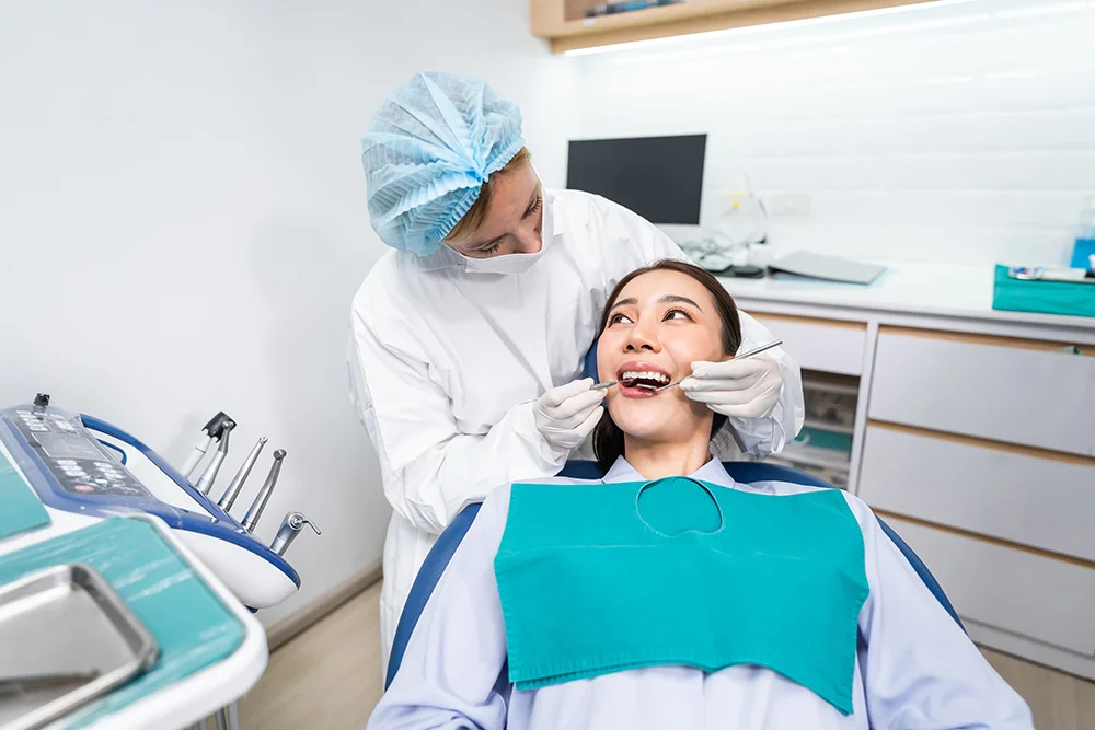 Caucasian dentist examine tooth for young girl at dental health clinic. Attractive woman patient lying on dental chair get dental treatment from doctor during procedure appointment service in hospital